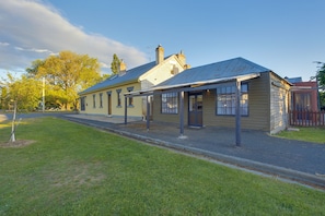A historic building with a flat roof, large windows, and a small porch area. - White's Corner (Bothwell)