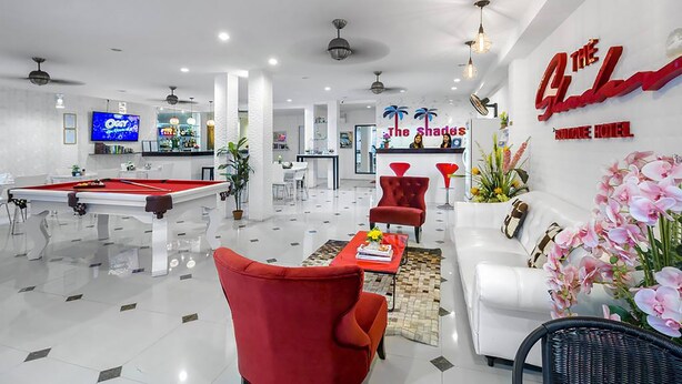 A modern hotel lobby with a pool table, red chairs, a white sofa, and a reception desk. - The Shades Boutique Hotel Patong Phuket (Patong)