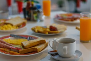 A breakfast table with plates of toast, scrambled eggs, and a cup of coffee. - The Shades Boutique Hotel Patong Phuket (Patong)