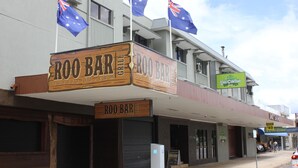 Un edificio con un letrero que dice 'Roo Bar' y banderas australianas.