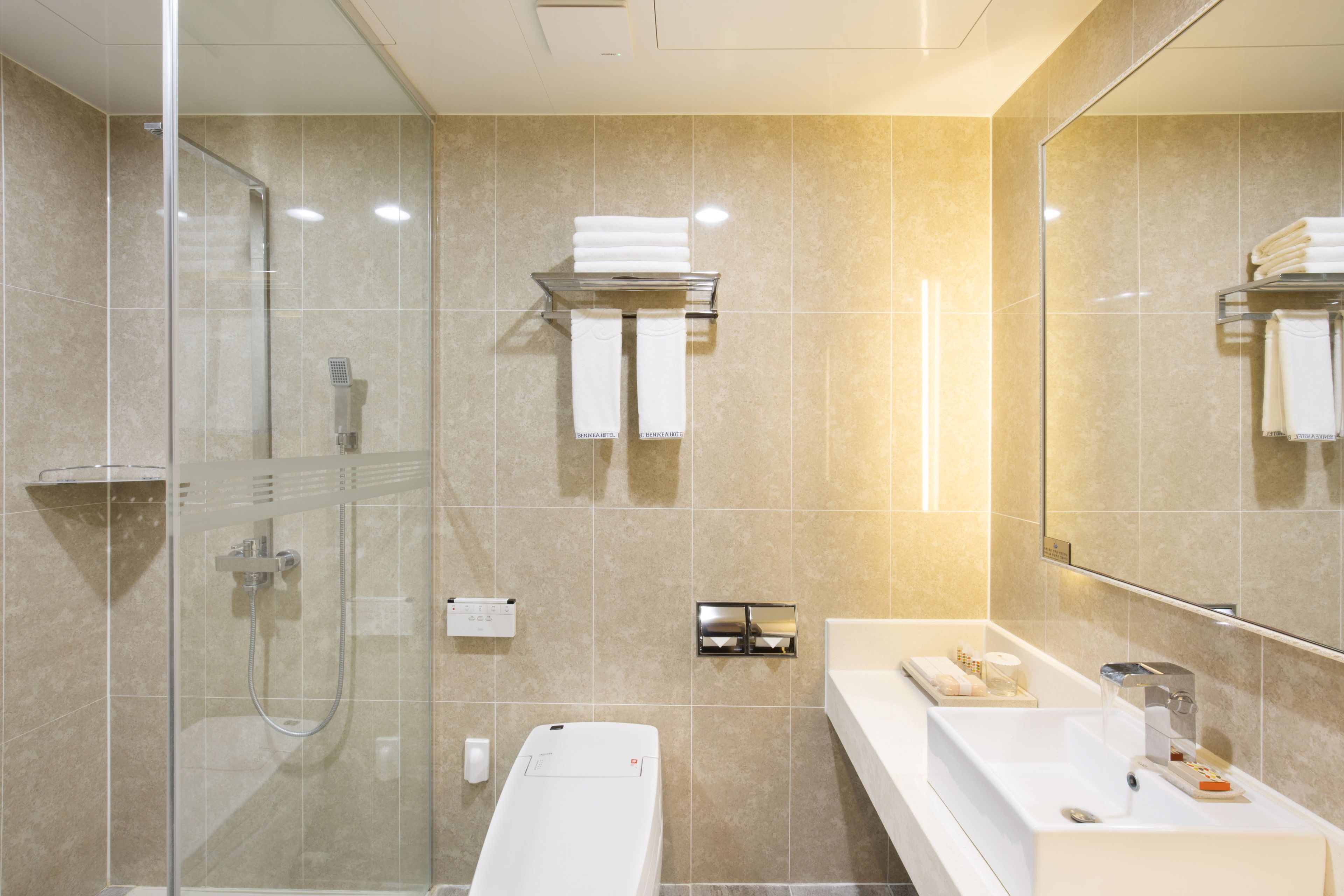 A modern bathroom with a glass-enclosed shower, a white bathtub, and a vanity with a mirror.