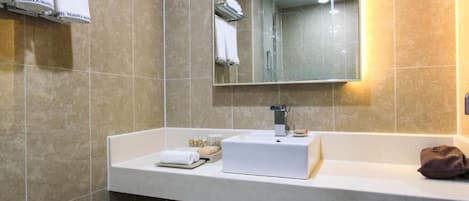 A modern bathroom with a white sink, a mirror, and a towel rack.