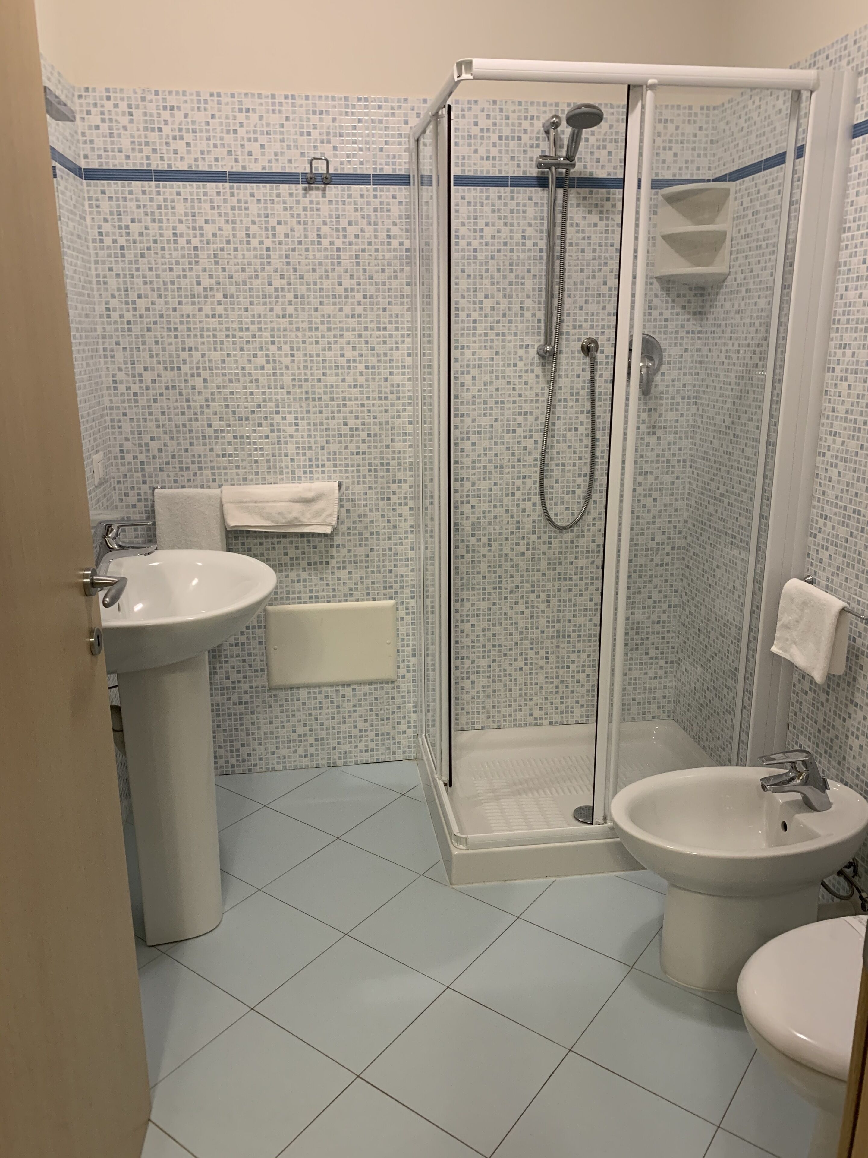 A bathroom with a shower, sink, and toilet.