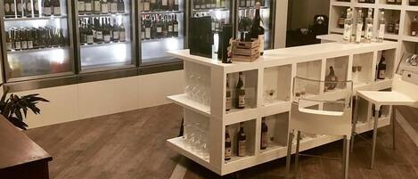 A wine and liquor store with shelves stocked with bottles and glasses.