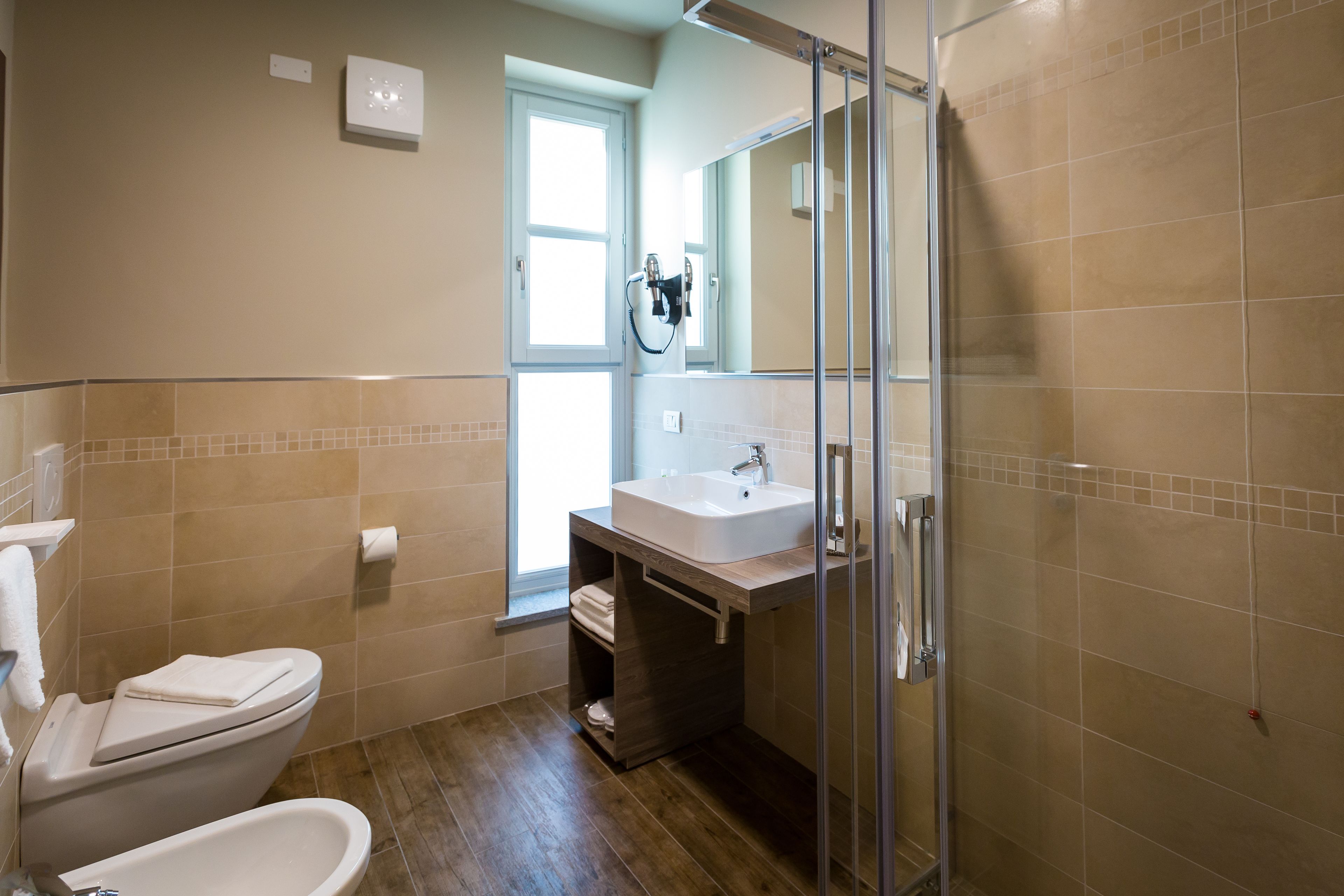 Une salle de bain avec des toilettes, un lavabo et une douche.