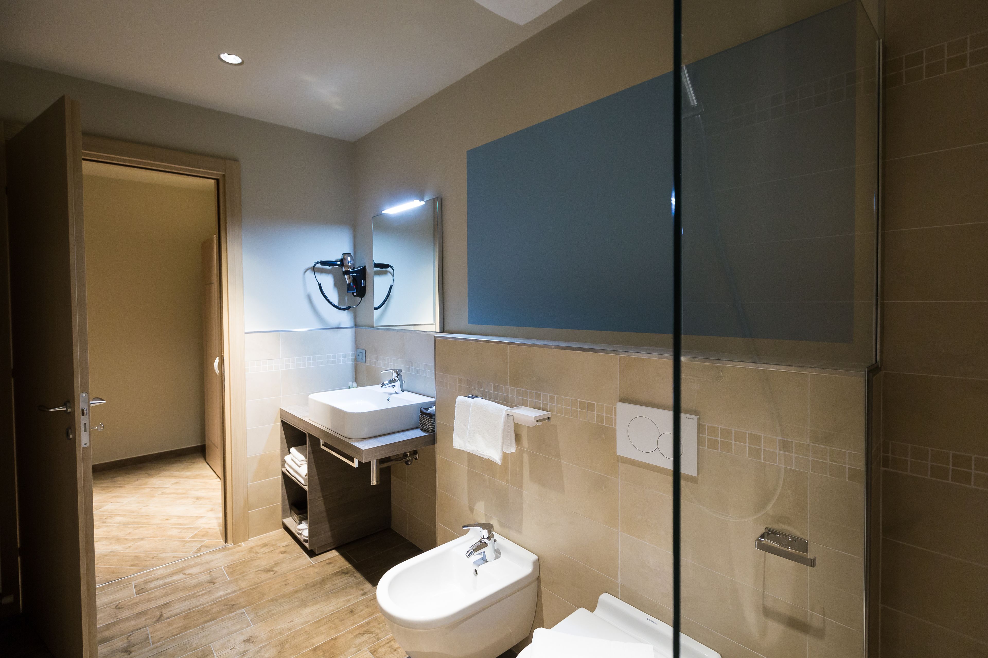 Une salle de bain moderne équipée d’une douche, d’un lavabo et de toilettes.