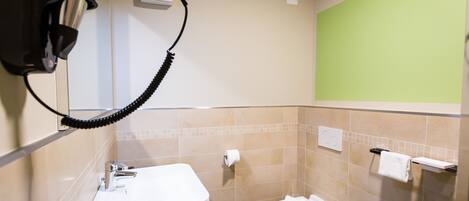 Un baño con lavamanos, inodoro y perchero para toallas.