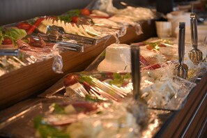 A buffet with various food items and utensils.