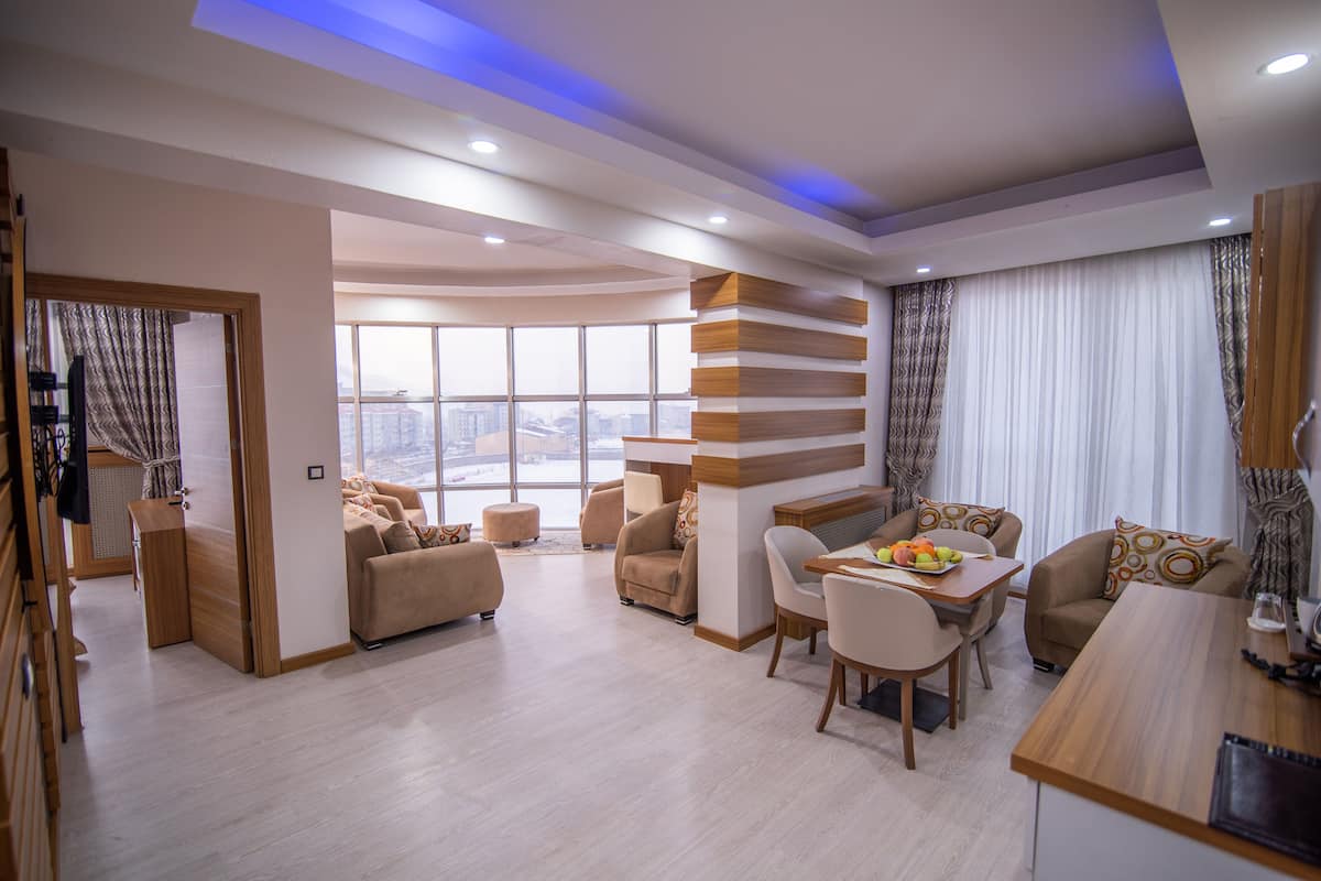 A modern living room with a dining area, large windows, and a view of the city.
