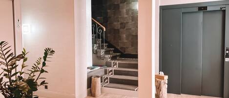 Un interior moderno con una escalera, una araña y una puerta marcada con el número 4.