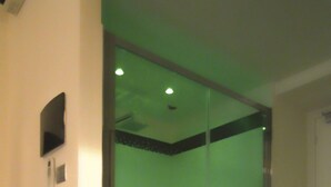 A room with a large glass door, a radiator, and a small screen on the wall. - Andrea Doria Resort (Rome)