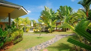 A garden pathway leading to a building with a covered entrance. - Palm Garden Resort Khaolak (Takua Pa)