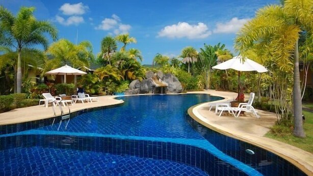 A swimming pool with lounge chairs and umbrellas, surrounded by tropical vegetation. - Palm Garden Resort Khaolak (Takua Pa)