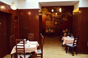 A restaurant with wooden walls and tables set with tableware. - Hotel Meran (Prague)