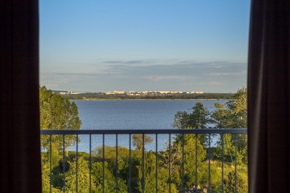A view from a balcony overlooking a lake with trees and buildings in the distance. - Blue Marine Mielno (Mielno)