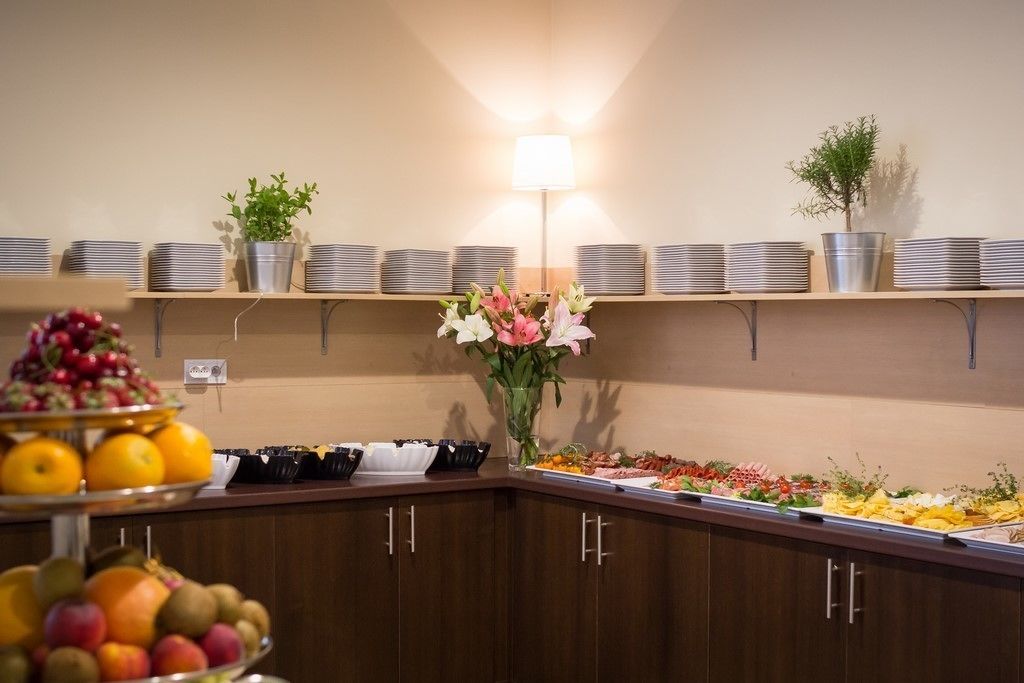 A buffet setup with various food items and a vase of flowers.