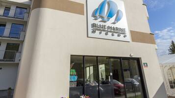 Welcome to Blue Marine, a business establishment with a central entrance and lush greenery.