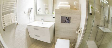 A modern bathroom with a sink, toilet, and glass-enclosed shower.