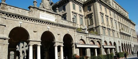 A historic building with classical architecture, featuring a series of arches and columns, and a sign indicating it is a civil commemoration site.
