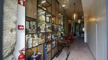 A hallway with a glass display of various items, a fire extinguisher, and a fire alarm on the wall.