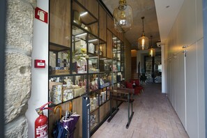 A hallway with a glass display of various items, a fire extinguisher, and a fire alarm on the wall. - Bemyguest - Loft Guest House Jardim das Mães Charming (Viseu)
