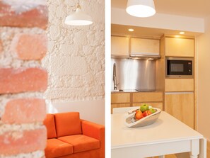 A modern kitchen with a built-in oven, microwave, and stainless steel appliances. - Bemyguest - Loft Guest House Jardim das Mães Charming (Viseu)
