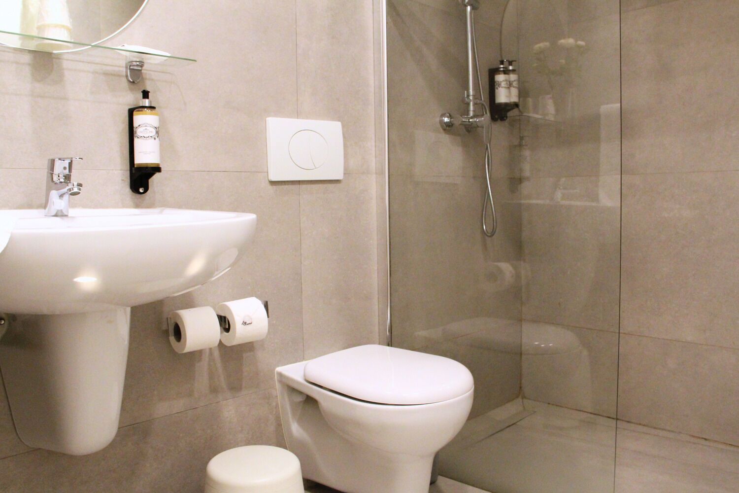 Une salle de bain moderne avec un lavabo, des toilettes et une douche à parois de verre.