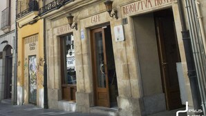 Edificio de un hostal con un letrero que dice "HOSTEL" y "REVOLTVA HOSTEL", indicando que hay un restaurante en su interior.