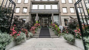 La entrada del Hotel BiancamariaPalace, con fachada de piedra, un acceso central y una escalera que conduce a las puertas.