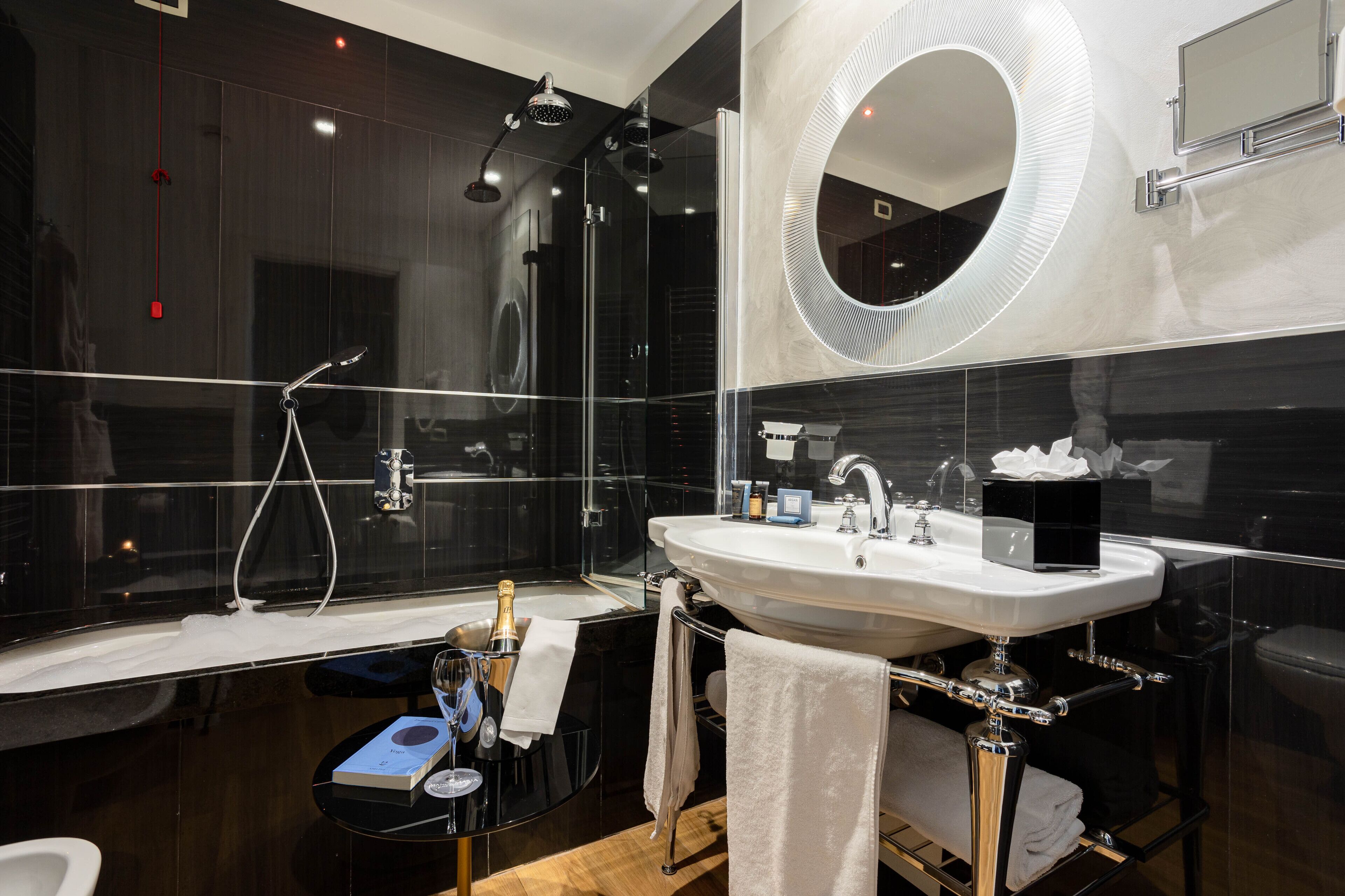 Un baño moderno con ducha envuelta en vidrio, un espejo grande y un tocador con lavamanos.