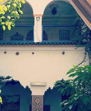 A building with a traditional architectural style, featuring arched windows and a tiled roof.
