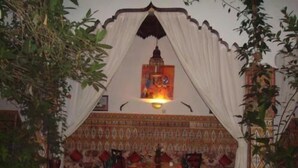 A room with a red carpeted area, a white canopy, and a patterned wall. - Riad Maryam (Taroudant)