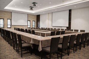 A conference room with long tables, chairs, a projector, and screens. - DoubleTree by Hilton Nairobi Hurlingham (Nairobi)