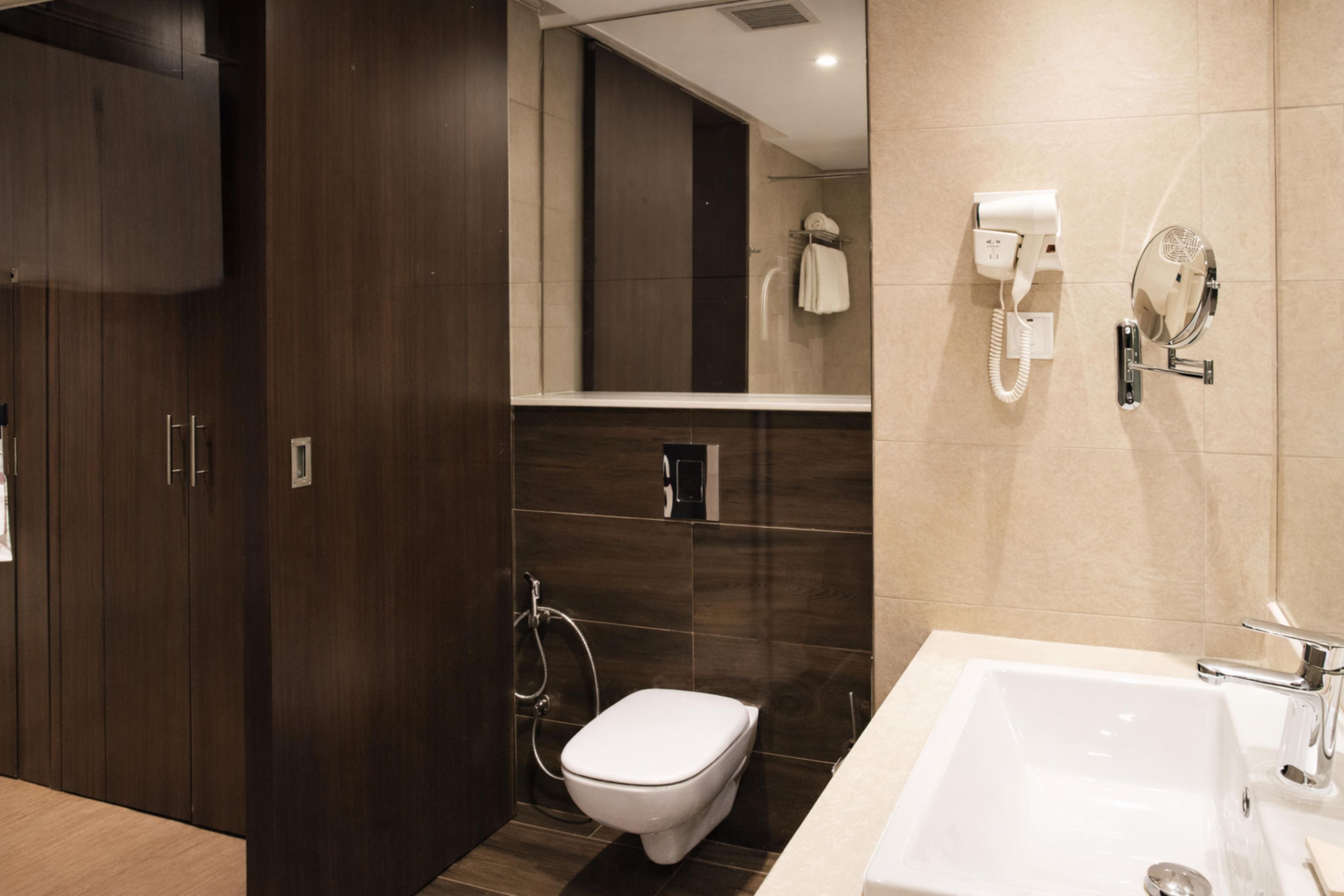 A modern bathroom with a toilet, bidet, and a large sink.