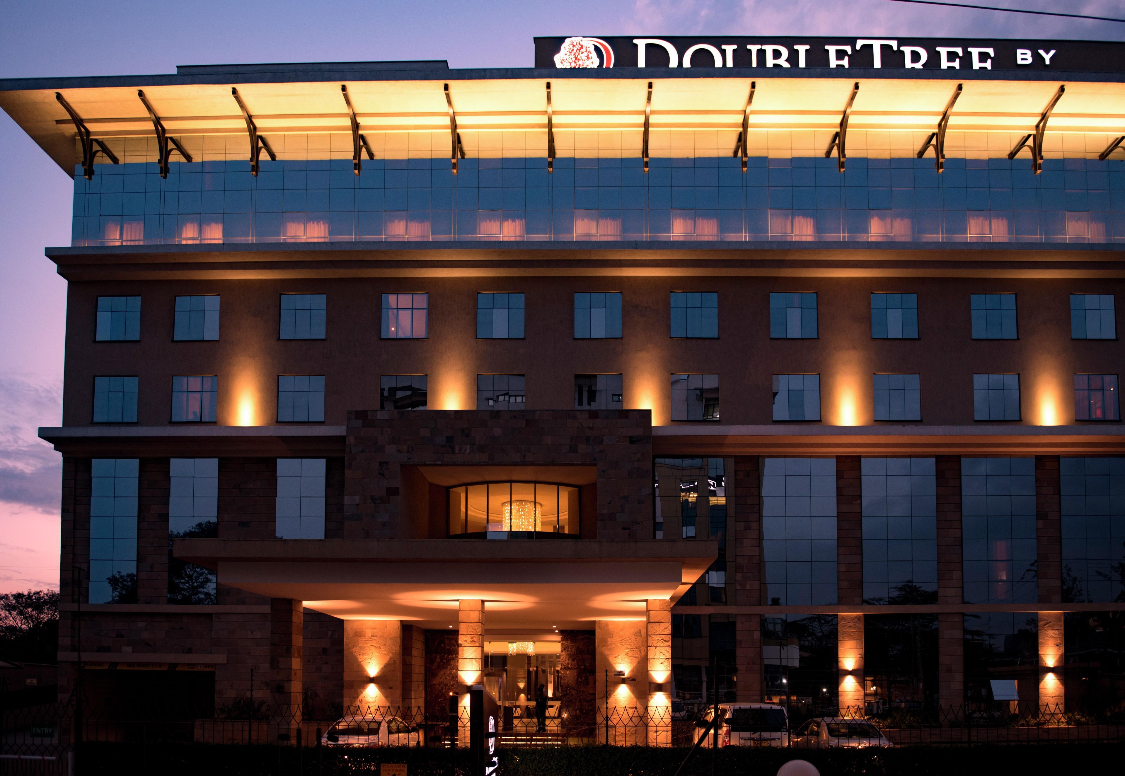 A hotel with a modern facade, multiple floors, and a prominent entrance with lighting.