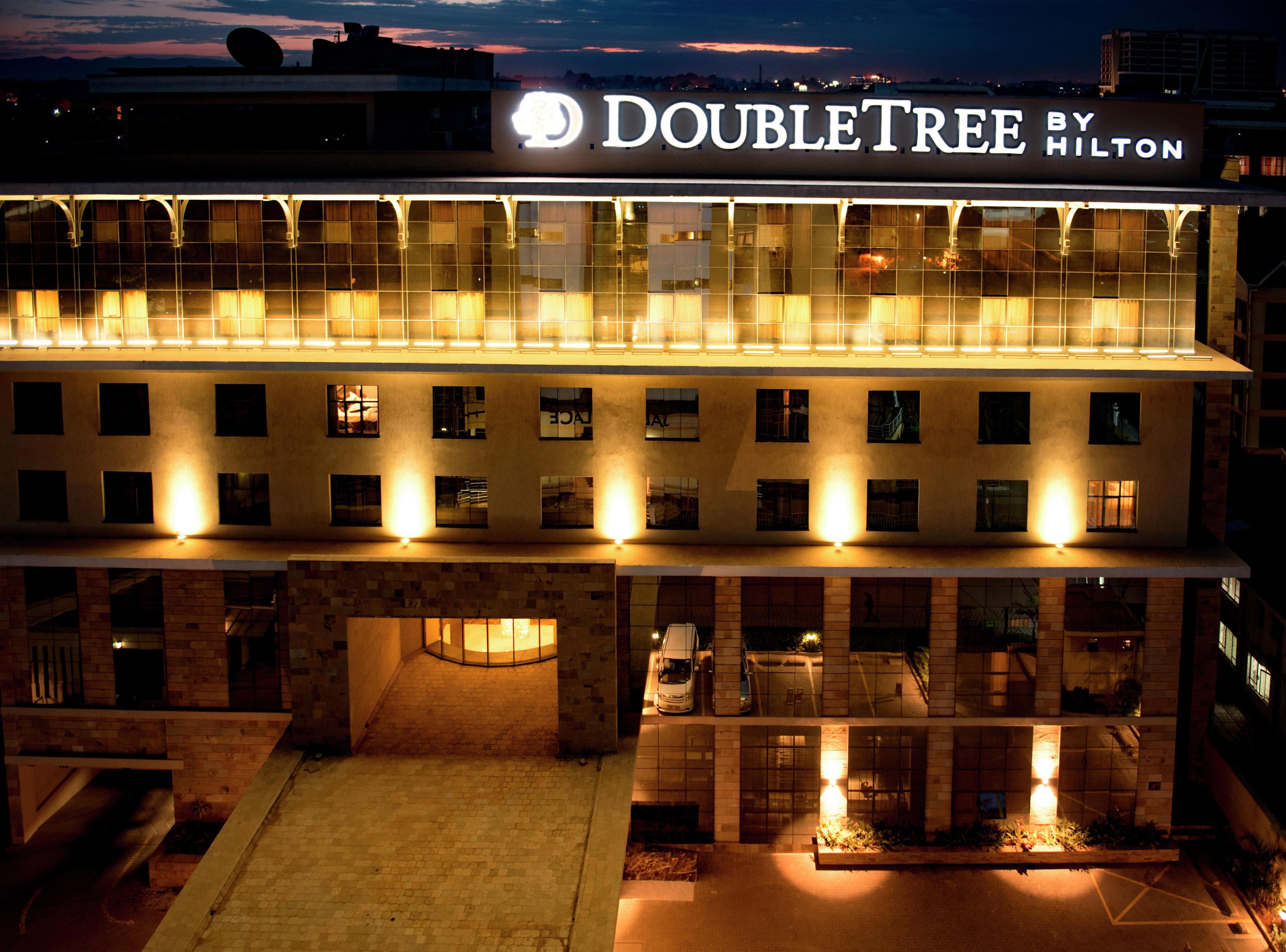 Un hotel con un letrero que dice 'DOUBLETREE BY HILTON', varias ventanas y fachada de ladrillo.