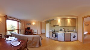 A compact living space with a kitchenette, dining area, and a small bedroom. - La Pleta de Soldeu Apartments (Soldeu)