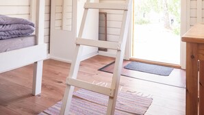 A wooden ladder in a room with white walls and a wooden floor. - Björkbackens Stugby - Campground (Vimmerby)