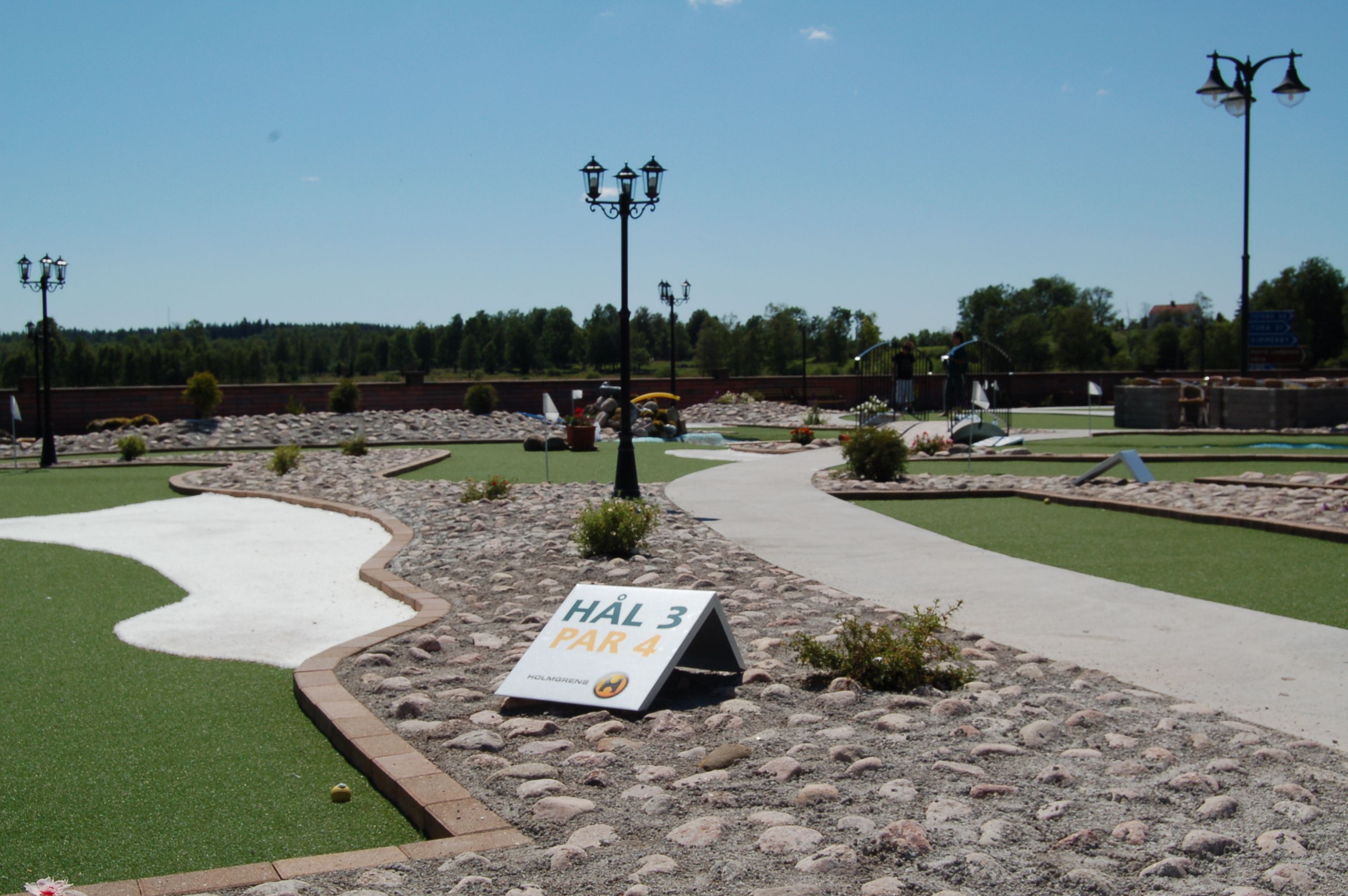A miniature golf course with a sign indicating 'HAL 3 PAR 4'.