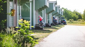 A row of green mobile homes with cars parked in front. - Björkbackens Stugby - Campground (Vimmerby)