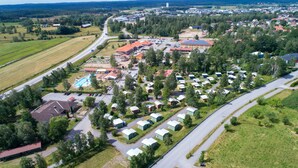 An aerial view of a campground with RVs, a swimming pool, and a large building with a red roof. - Björkbackens Stugby - Campground (Vimmerby)