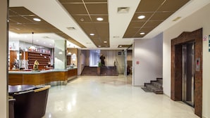 A hotel lobby with a reception desk, a staircase, and an elevator. - Hotel Macola (Plitvicka Jezera)