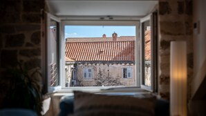 A room with a view of a building with a tiled roof through an open window. - Villa Mirabilis, stunning superior villa, Dubrovnik Old Town (Dubrovnik)