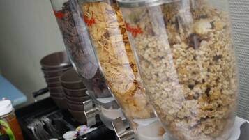 A food dispenser with various granola and cereal options.
