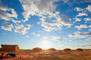 A desert landscape with multiple tents and a clear sky.