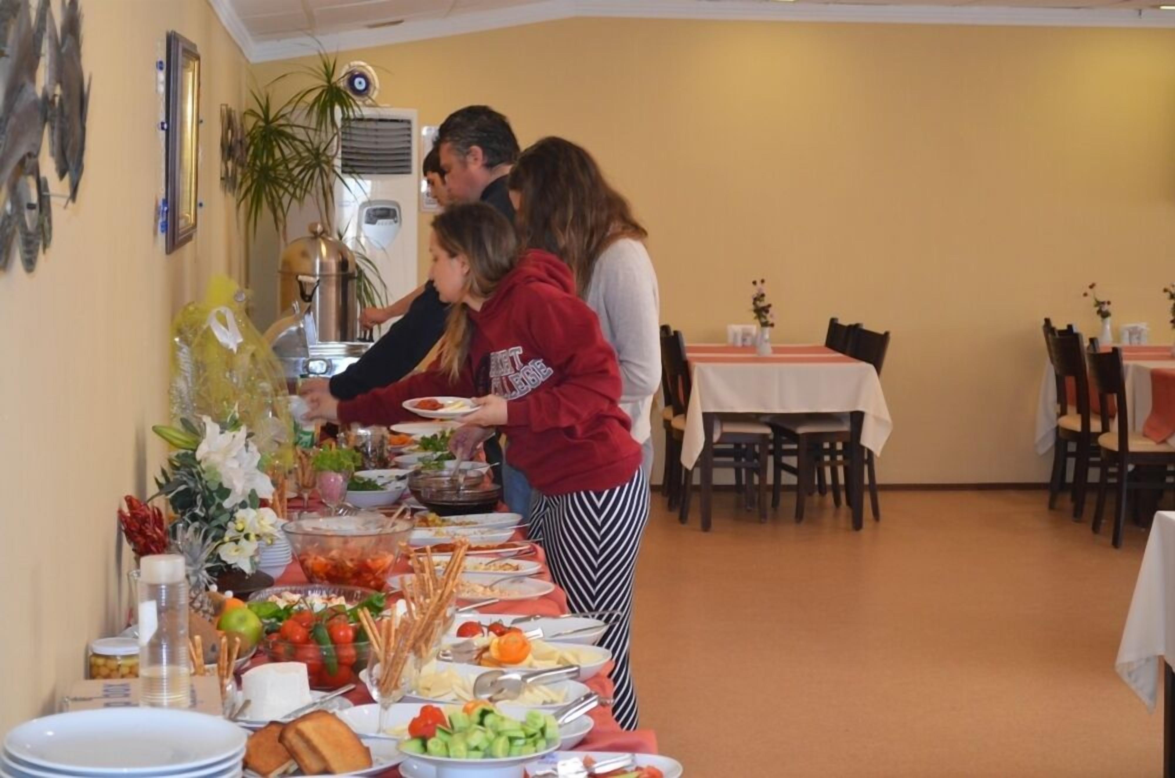 A buffet setup with various food items and a person serving.