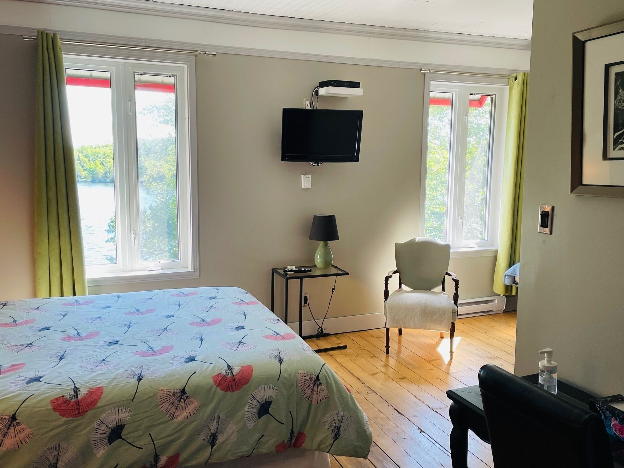 A hotel room with a bed, a chair, a TV, and a small table.