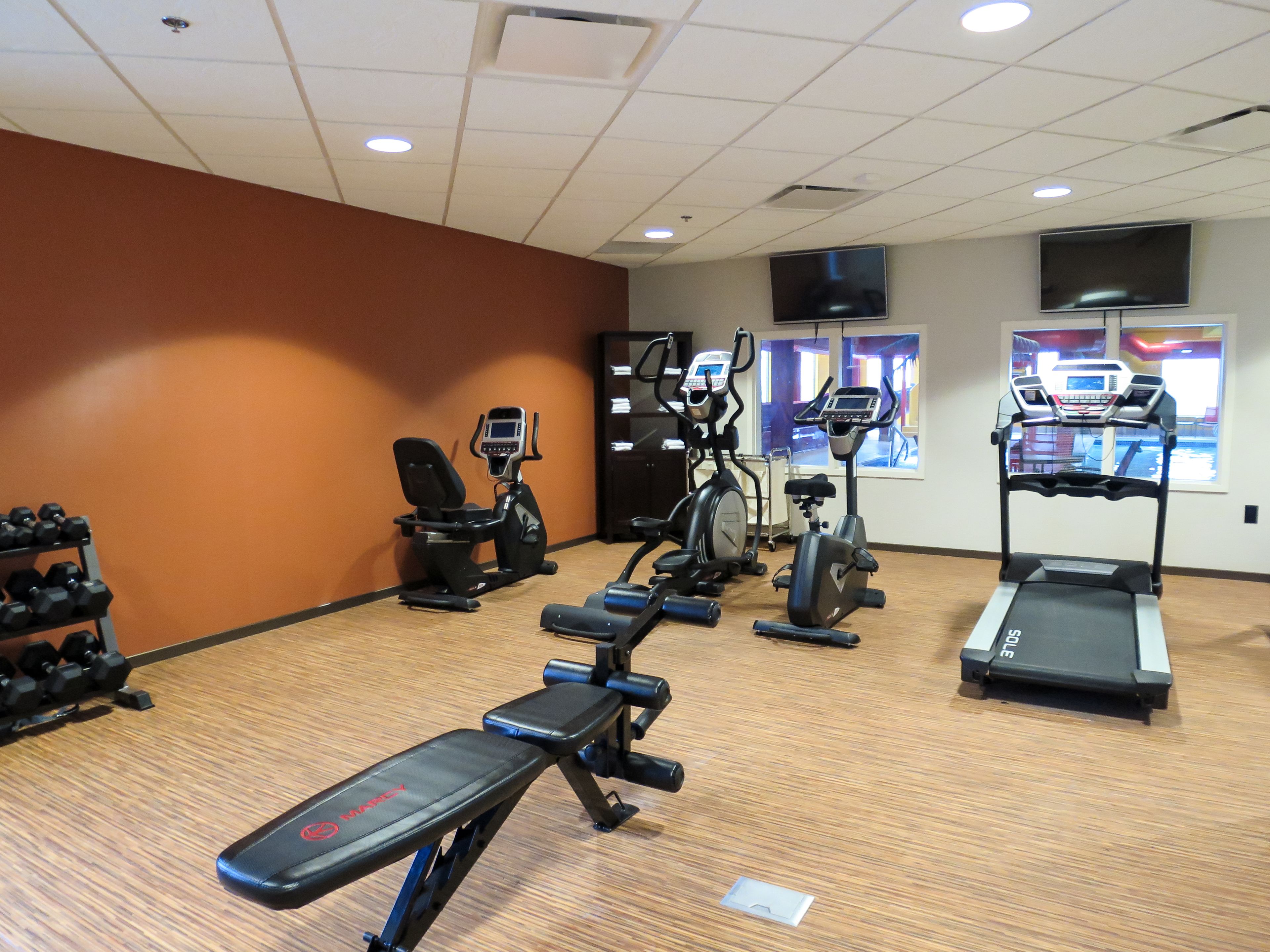A gym with treadmills, elliptical machines, and free weights.