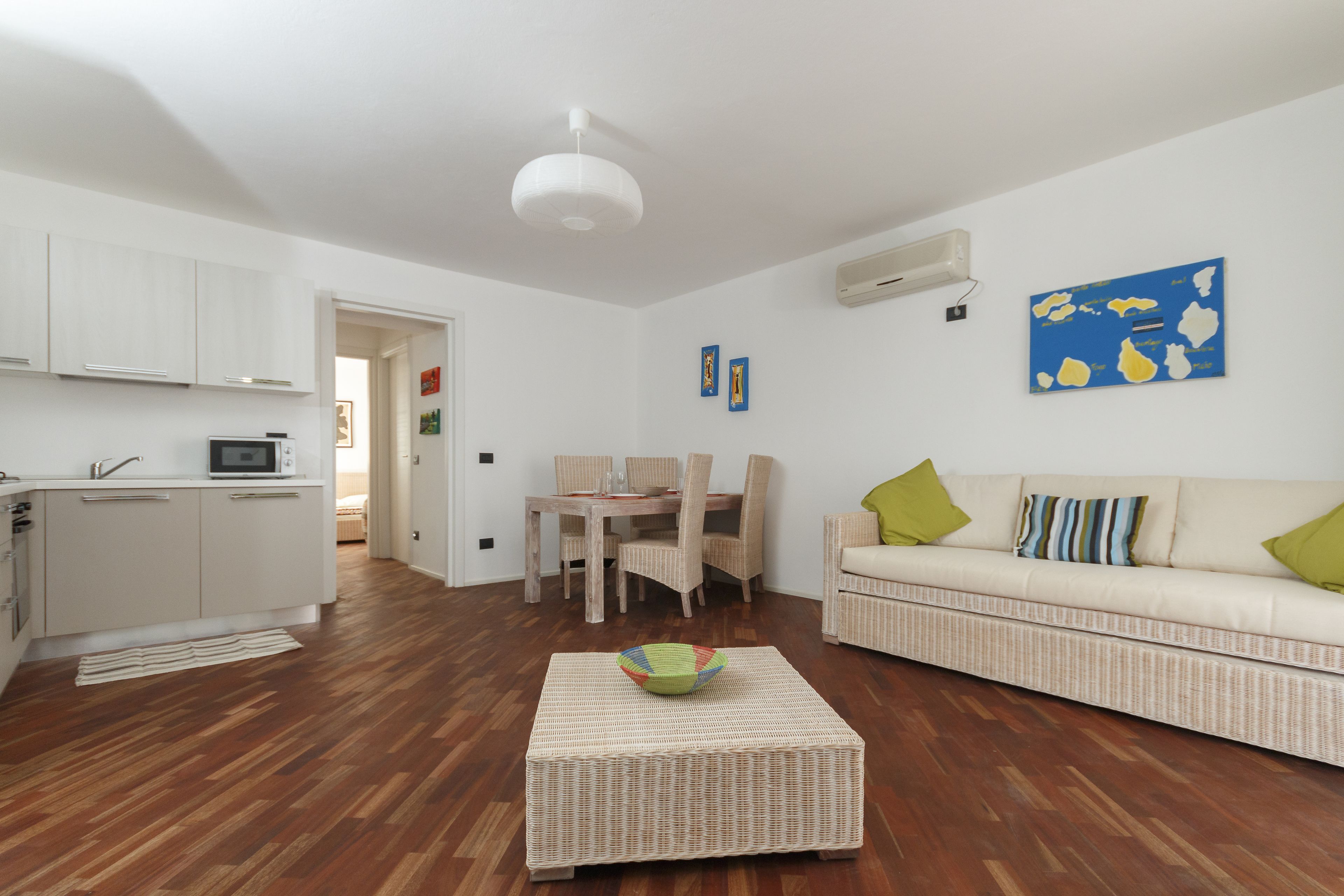 A modern living room with a sofa, a coffee table, and a dining area with chairs and a table.