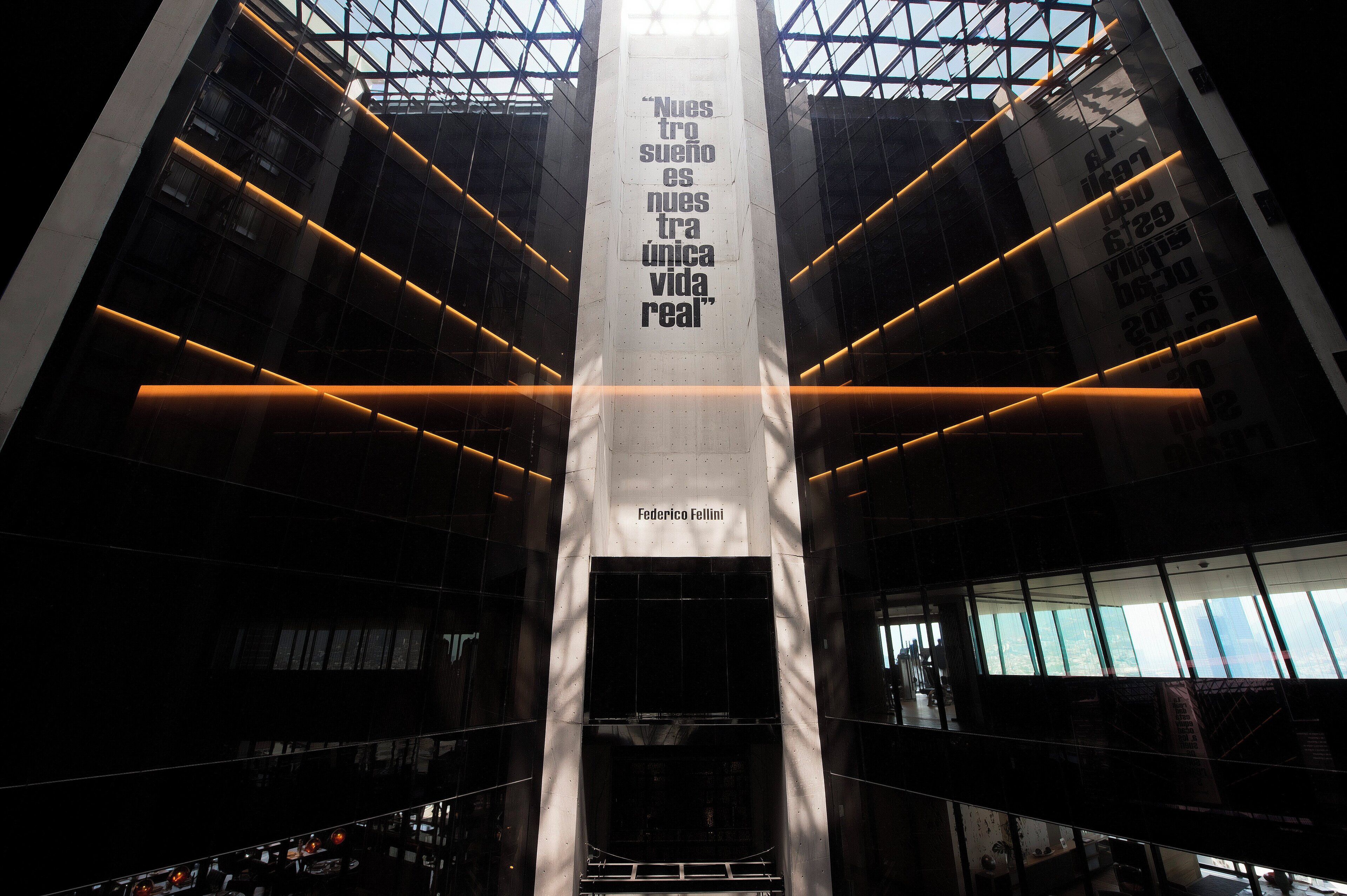 A modern building with a central column and reflective glass windows.